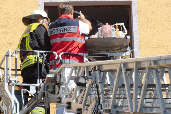 Beim Patiententransport mittels Drehleiter wird der Betroffene immer vom Notarzt – normalerweise mit Helm – begleitet. Foto: Maximilian Kippnich